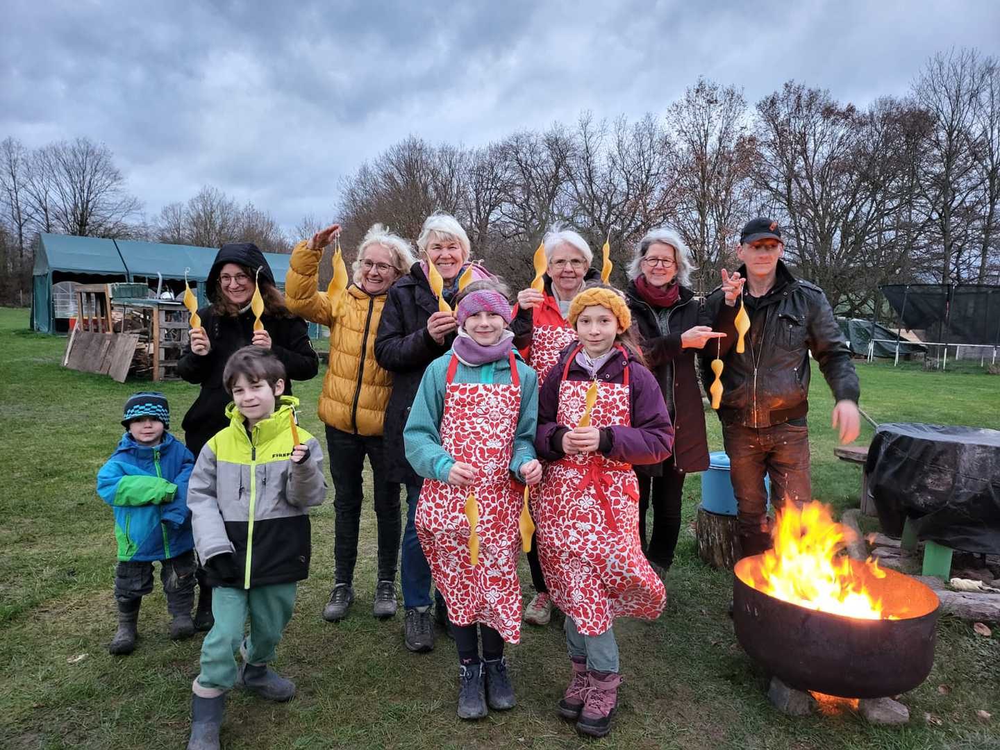 Gruppe beim Kerzenziehen an der Feuerschale vor dem Tipi