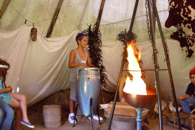 Kinder sitzen im Tipi um die Feuerschale